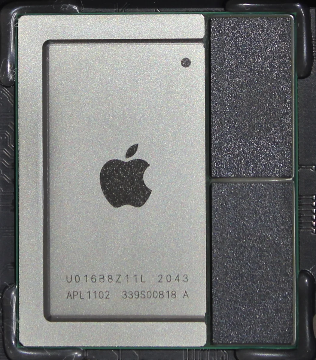 녹색 회로기판 위에 놓인 사각형 금속 덮개의 Apple M1 칩 사진. 기판에는 여러 부품과 연결 단자가 보인다.